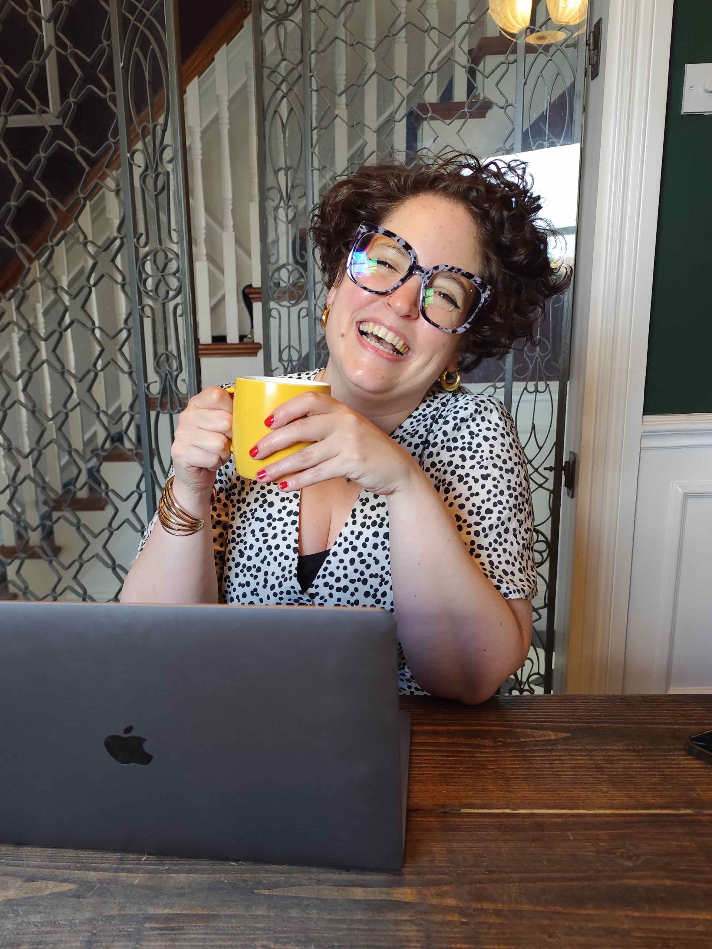 Magdalena Mahdy working outdoors with laptop and coffee